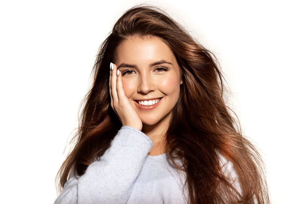 Smiling woman with healthy, glossy hair after Aveda Botanical Repair treatment at The Pamper Suite in Bexley.