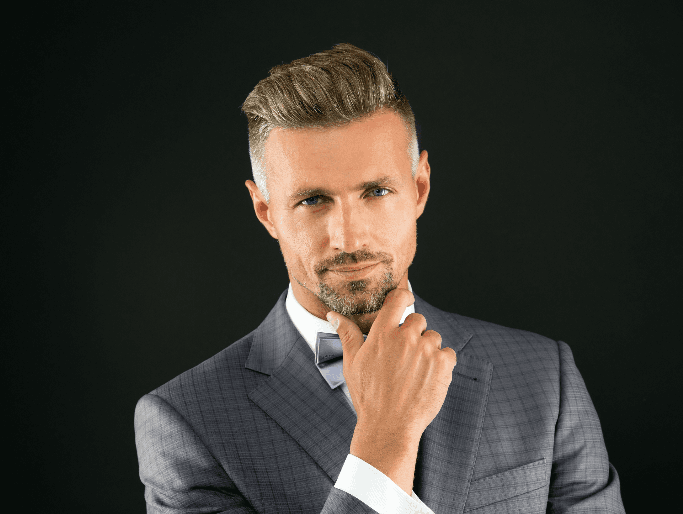 Stylish man in a tailored suit with a sharp haircut and brushed-back style — representing expert gentlemen’s grooming at The Pamper Suite in Bexley.