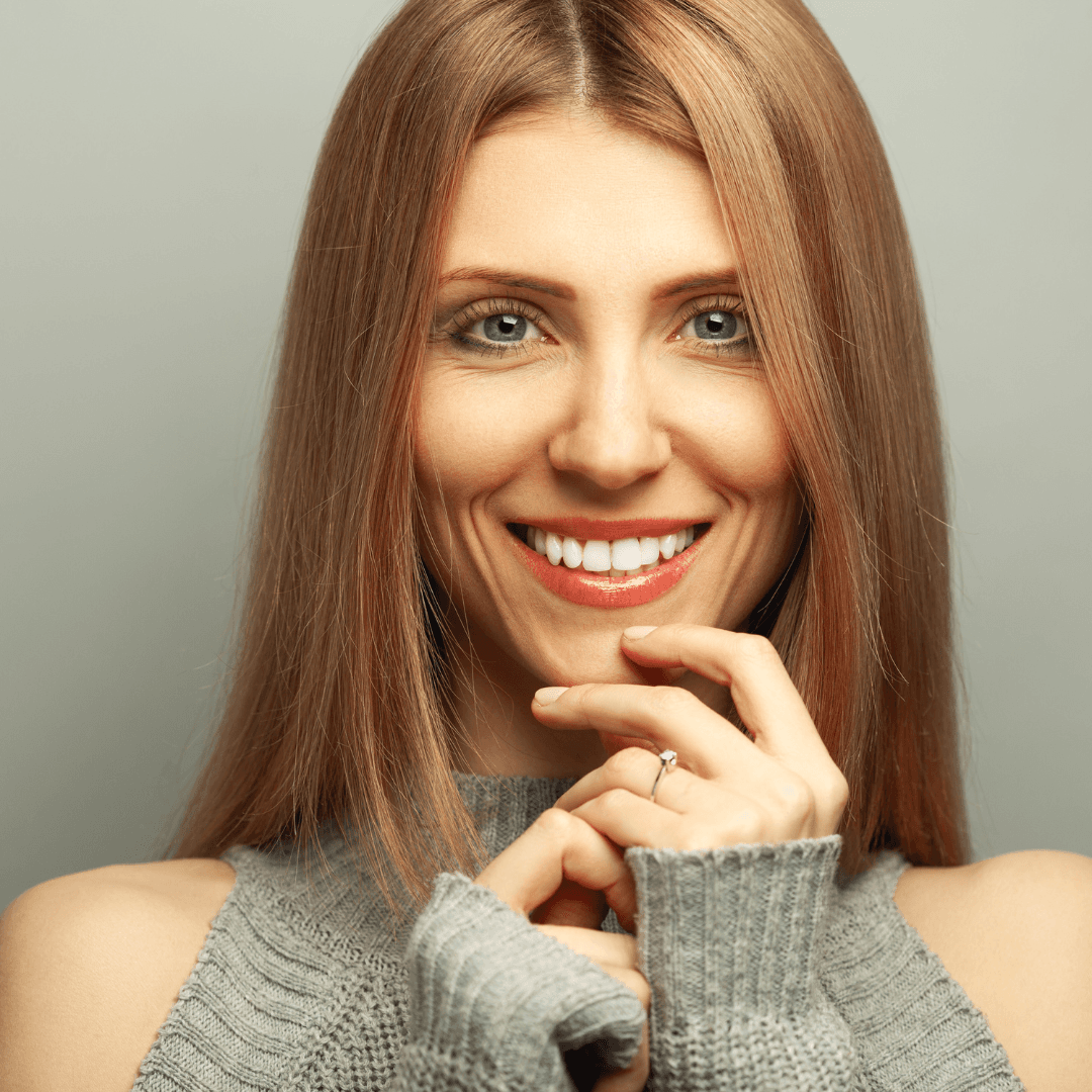 Smiling woman with sleek, glossy blonde hair – showcasing the results of professional hair colouring services at The Pamper Suite in Bexley.