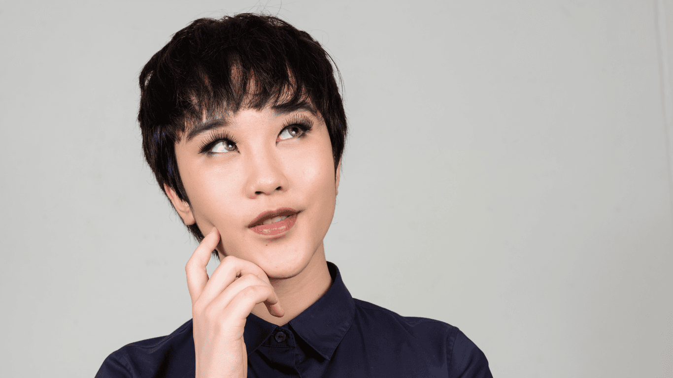 Person with a short textured haircut and thoughtful expression, wearing a navy shirt. Represents inclusive hairdressing for non-binary clients at The Pamper Suite in Bexley.